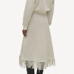 Back view of white odin bomber jacket on model wearing white bennie skirt and boots, against a white background.
