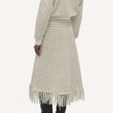 Back view of white odin bomber jacket on model wearing white bennie skirt and boots, against a white background.