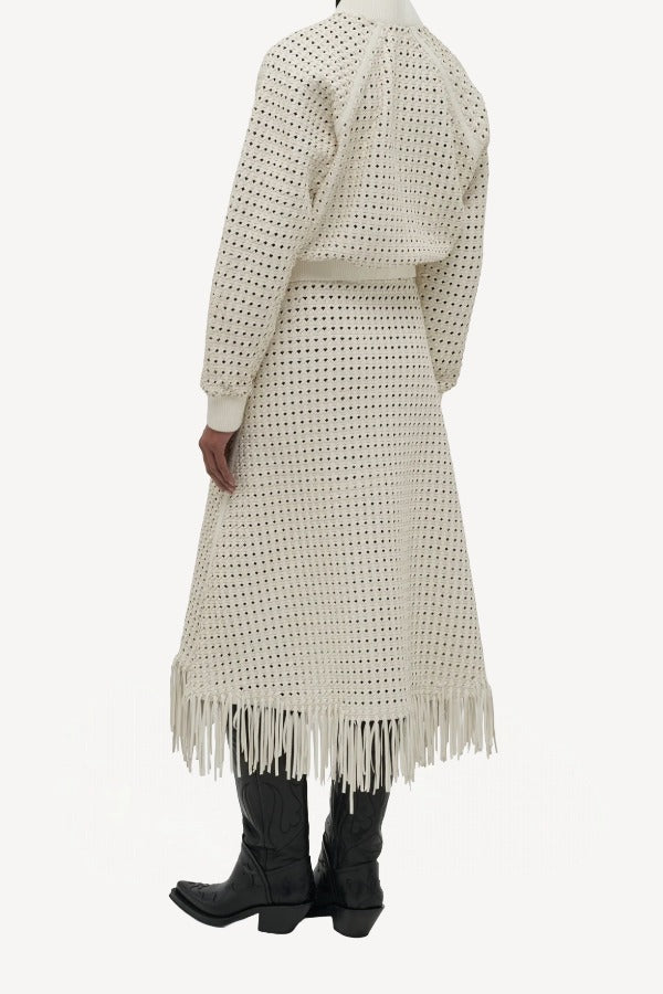 Back view of white odin bomber jacket on model wearing white bennie skirt and boots, against a white background.