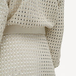 Alternate back closeup view of white odin bomber jacket on model wearing white bennie skirt, against a white background.