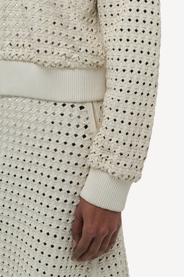 Front closeup view of white odin bomber jacket on model wearing white bennie skirt, against a white background.