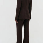Back view of chocolate stephanie blazer on model wearing chocolate pants, against a white background.