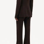 Back view of chocolate vesta pants on model wearing chocolate stephanie blazer and sneakers, against a white background.