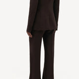 Back view of chocolate vesta pants on model wearing chocolate stephanie blazer and sneakers, against a white background.