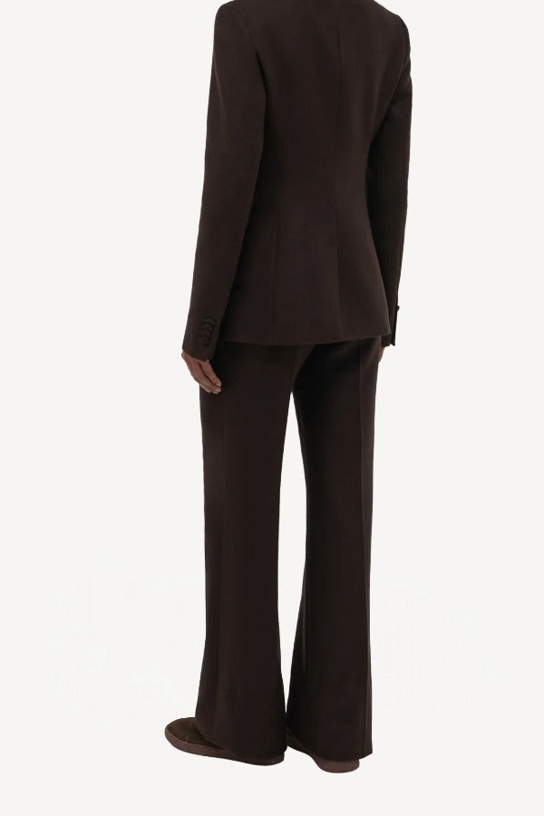 Back view of chocolate vesta pants on model wearing chocolate stephanie blazer and sneakers, against a white background.