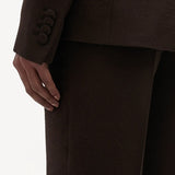 Back closeup of chocolate vesta pants on model wearing chocolate stephanie blazer, against a white background.