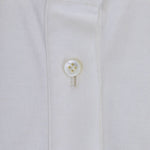 Front closeup view of white daphne polo shirt with no model shown.