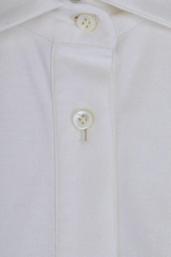 Front closeup view of white daphne polo shirt with no model shown.