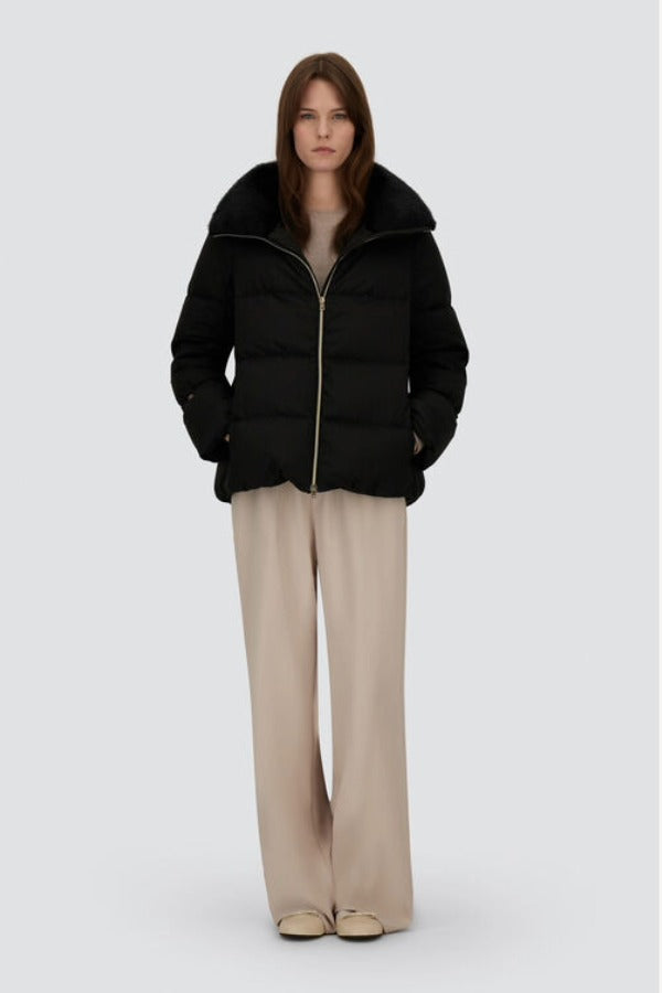 Front open view of black jacket in arendelle on model wearing beige pants, against a white background.