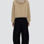Back view of chantilly knitted jacket on model wearing black pants and sneakers, against a white background.
