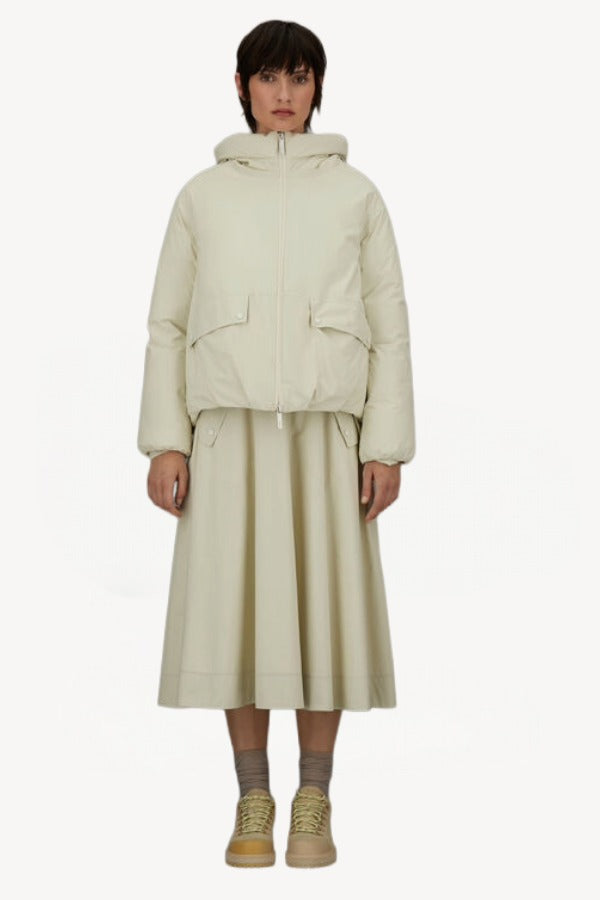 Alternate front view of panna scuro jacket on model wearing cream skirt and sneakers, against a white background.