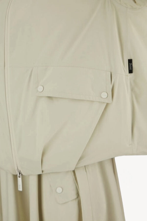 Front closeup view of panna scuro jacket on model wearing a cream skirt, against a white background.