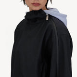 Side view of black wool jacket on model, against a white background.