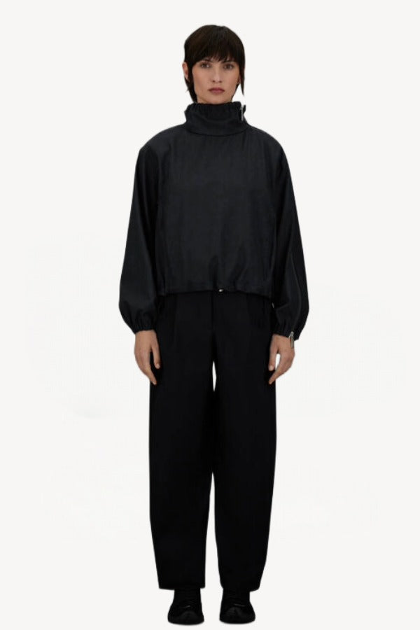 Front view of black wool jacket on model wearing black pants, against a white background.