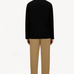 Back view of cammello laminar trousers on model wearing black t-shirt and sneakers, against a white background.