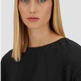 Front close up view of black pleated jersey t-shirt on model, against a white background.
