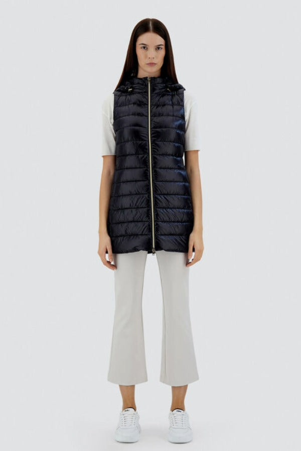 Front view of black serena vest on model wearing white pants, t-shirt and sneakers, against a white background.