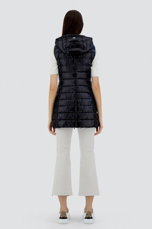 Back view of black serena vest on model wearing white t-shirt, pants and sneakers, against a white background.