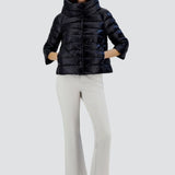 Front view of black sofia cape on model wearing white pants and sneakers, against a white background.