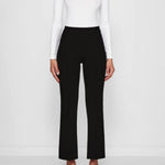 Front view of black geo kick pants on model wearing white t-shirt and flats, against a white background.