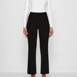 Front view of black geo kick pants on model wearing white t-shirt and flats, against a white background.