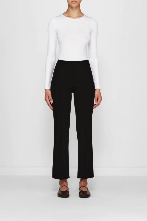 Front view of black geo kick pants on model wearing white t-shirt and flats, against a white background.