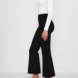 Side view of black geo kick pants on model wearing white t-shirt and flats, against a white background.