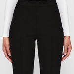 Front closeup view of black geo kick pants on model wearing white t-shirt, against a white background.