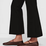 Side closeup view of black geo kick pants on model wearing flats, against a white background.