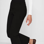 Alternate side view of black geo kick pants on model wearing white t-shirt and flats, against a white background.