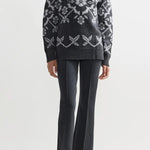 Front view of charcoal geo kick pants on model wearing a grey sweater and flats, against a white background.