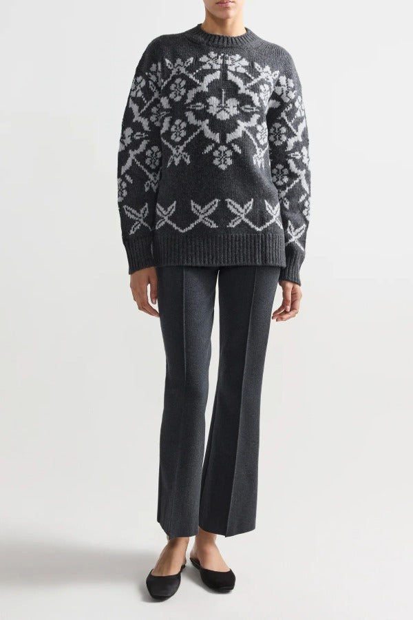 Front view of charcoal geo kick pants on model wearing a grey sweater and flats, against a white background.