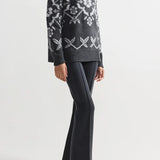 Alternate front view of charcoal geo kick pants on model wearing grey sweater and flats, against a white background.