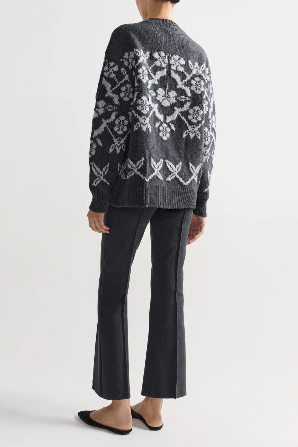 Back view of charcoal geo kick pants on model wearing grey sweater and flats, against a white background.