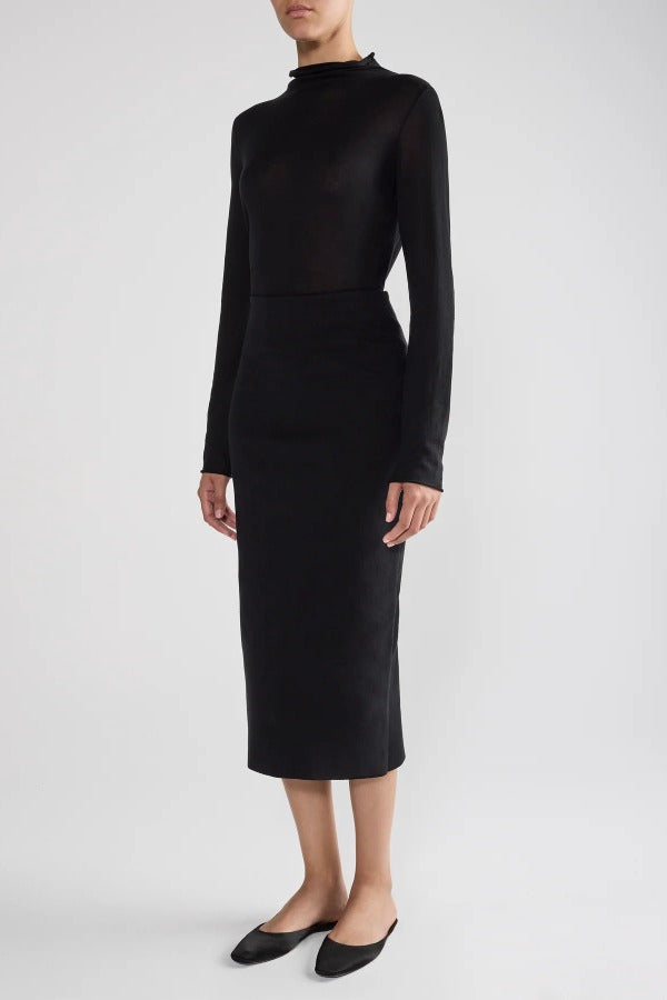 Front view of black geo petra skirt on model wearing black top and flats, against a white background.