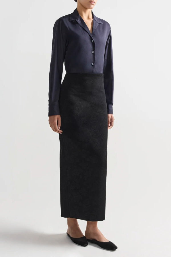 Front view of black lawton skirt on model wearing navy top and flats, against a white background.