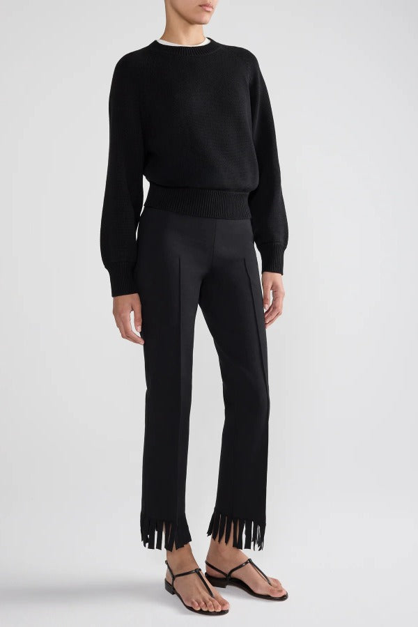 Front view of black lofty lara sweater on model wearing black pants and sandals, against a white background.