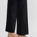 Bottom of pant closeup view of black tuxedo julep pant on model wearing flats, against a white background.