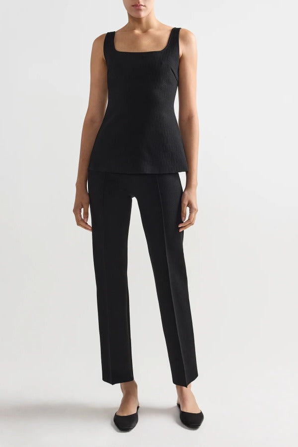 Front view of black combo windowpane inna top on model wearing black pants and flats, against a white background.