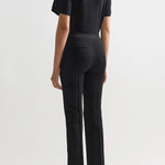 Back view of black combo windowpane louis pants on model wearing black t-shirt and flats, against a white background.