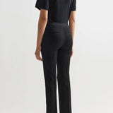 Back view of black combo windowpane louis pants on model wearing black t-shirt and flats, against a white background.
