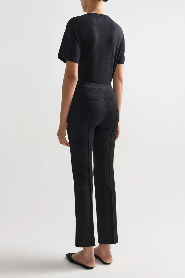 Back view of black combo windowpane louis pants on model wearing black t-shirt and flats, against a white background.