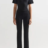 Alternate front view of black combo windowpane louis pants on model wearing black t-shirt and flats, against a white background.