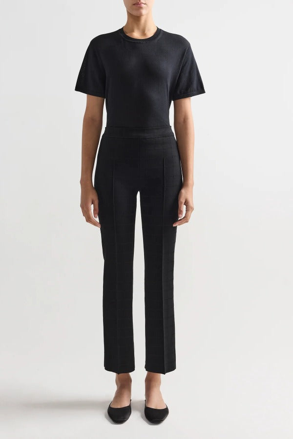 Alternate front view of black combo windowpane louis pants on model wearing black t-shirt and flats, against a white background.