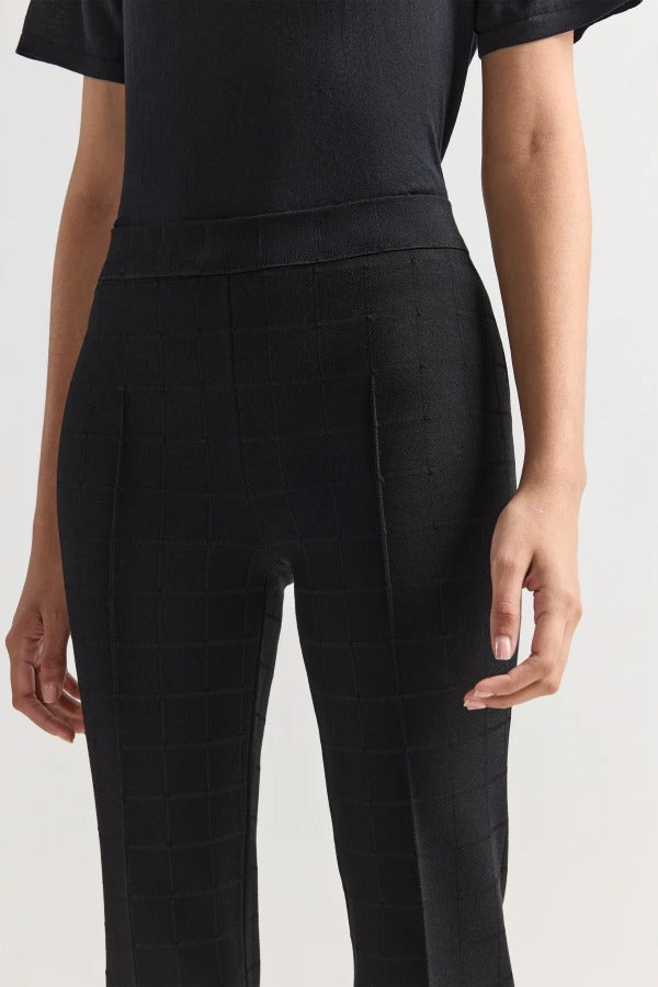 Front closeup of black combo windowpane louis pants on model wearing black t-shirt, against a white background.