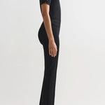 Side view of black combo windowpane louis pants on model wearing black t-shirt and flats, against a white background.