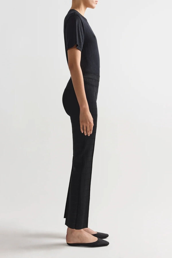 Side view of black combo windowpane louis pants on model wearing black t-shirt and flats, against a white background.