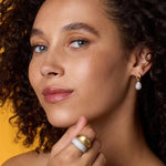 Front view of 18K WG YG Earrings on model, against an orange background.