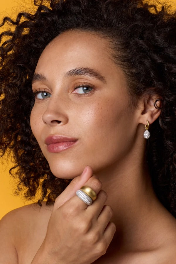 Front view of 18K WG YG Earrings on model, against an orange background.