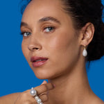 Front view of 18K WG YG Earrings on model, against a blue background.